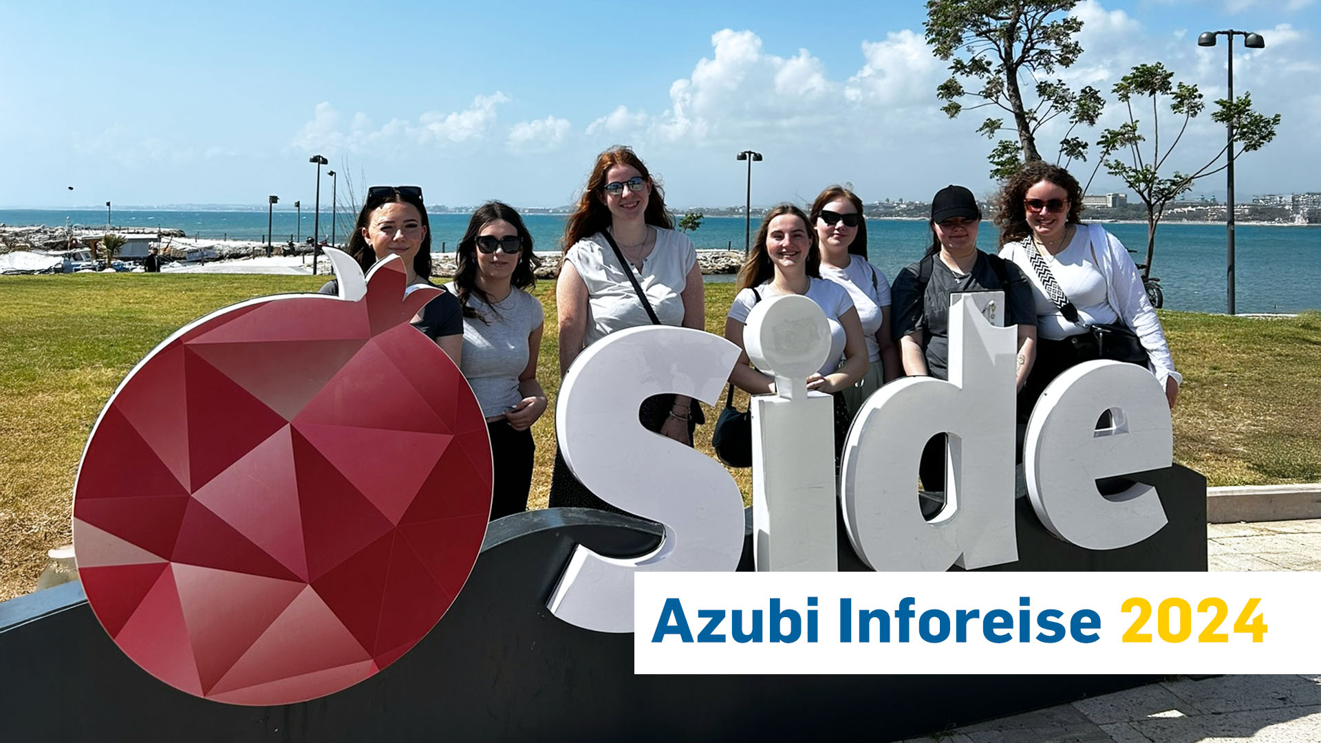 Unsere Auszubildenden auf Inforeise in Antalya, Gruppenbild vor Side Logo